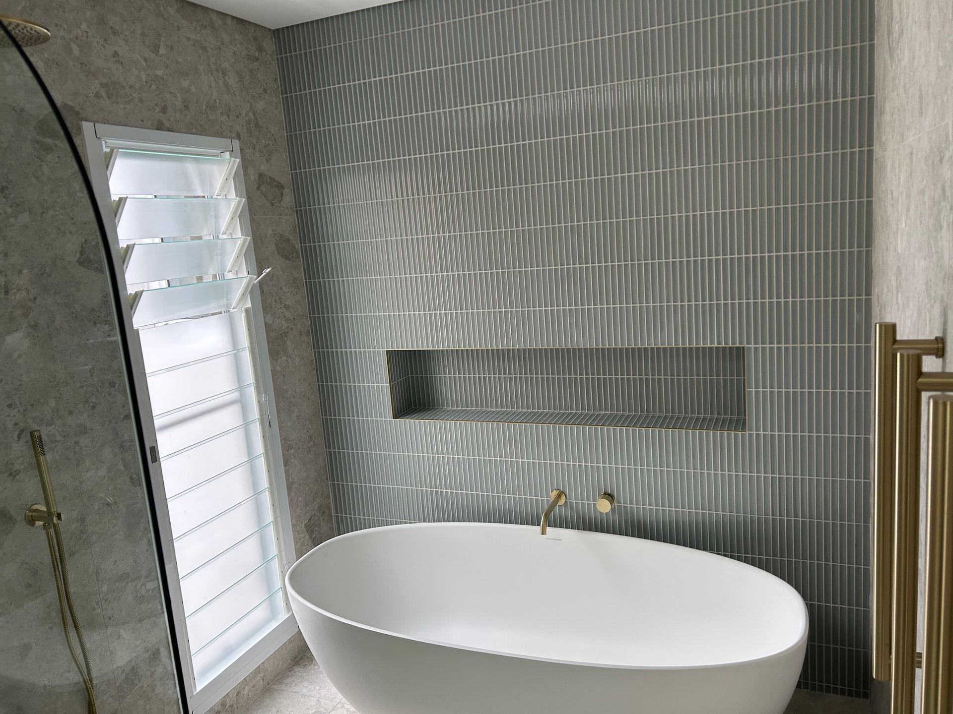 Finished luxury ensuite with freestanding bath and brass tapware