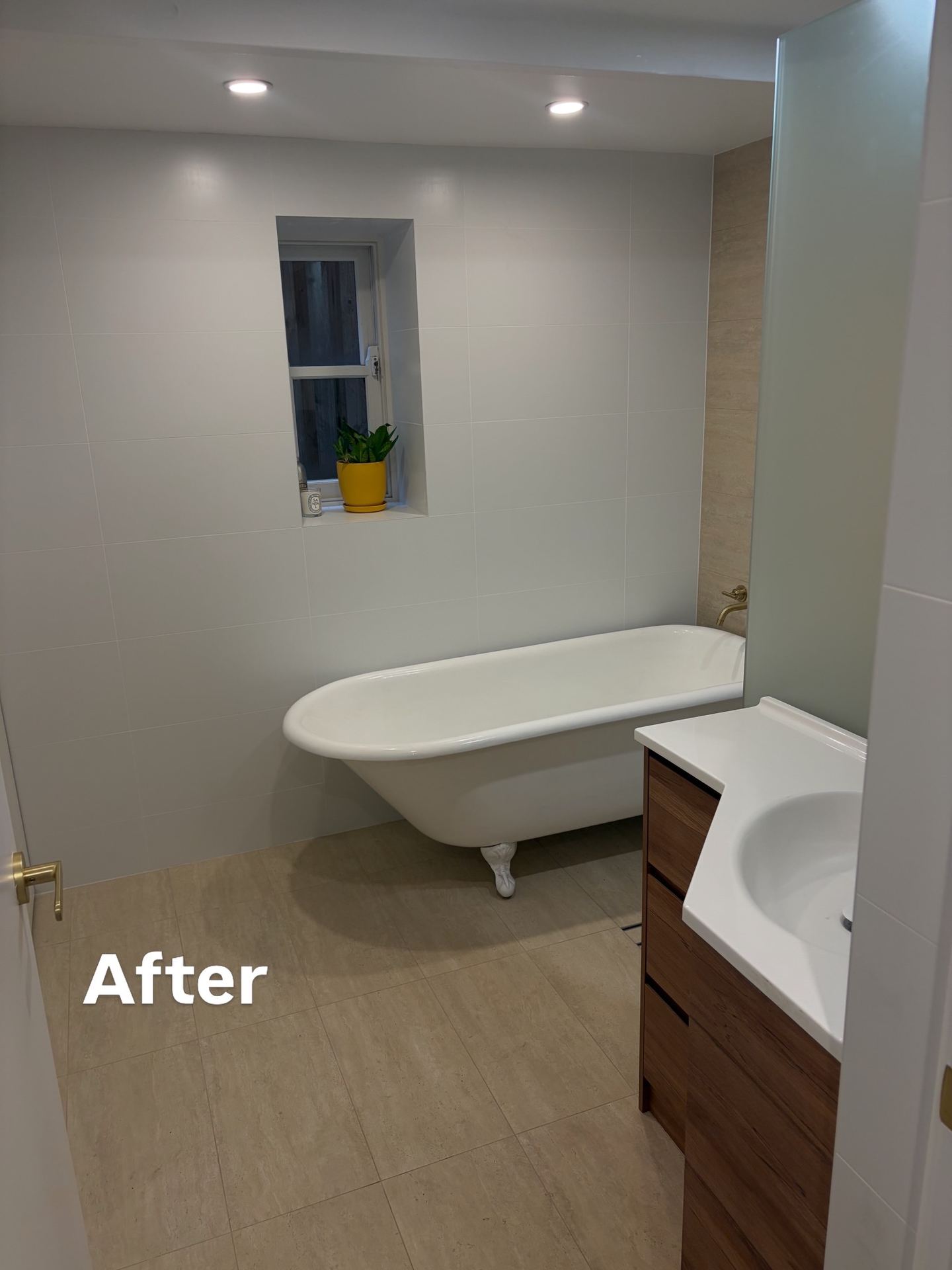 Same bathroom after renovation with clawfoot tub and modern vanity