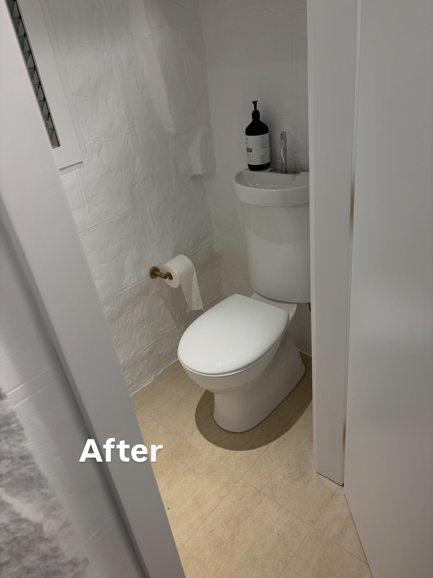 Renovated bathroom after with modern toilet and clean tiling
